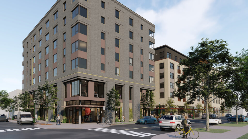 Modern multi-story building on an urban street corner. People walking, cycling, and cars passing by. Trees and greenery enhance the cityscape.