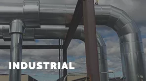 The image shows large industrial metal pipes under a cloudy sky, with a structure in the foreground. The word "INDUSTRIAL" is visible.